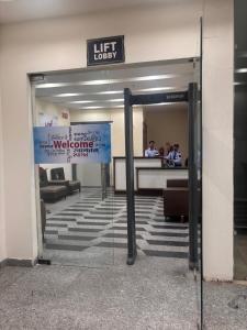 an open door to a lift lobby in a building at Good vibes only gaur city center studio apartment in Ghaziabad