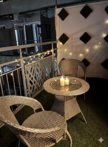 a patio with two chairs and a table with candles at Good vibes only gaur city center studio apartment in Ghaziabad