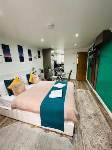 a bedroom with a large bed and a living room at Studio Flat in Wythenshawe