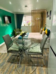 a living room with a glass table and a bed at Studio Flat in Wythenshawe +10 photos