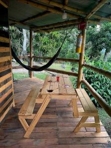 a wooden picnic table with a hammock on a wooden deck at La Florida Hotel in El Colegio