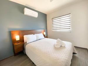 เตียงในห้องที่ Casa Moderna en privada con Alberca 5 min del Aeropuerto y Consulado Americano