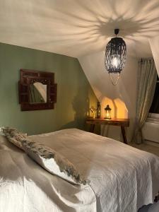 a bedroom with a white bed and a chandelier at Haus der Geschichten in Marienberg