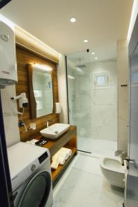 a bathroom with a toilet and a sink and a shower at Brilant Luxury Apartment in Gjirokastër +90 photos