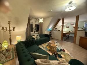 a living room with a green couch and a table at Haus der Geschichten in Marienberg