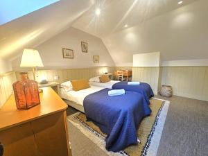 a bedroom with two beds with blue sheets and a desk at La Grive - Petit nid douillet proche de la plage in Étretat