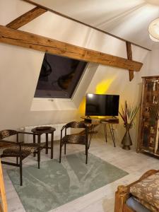 a living room with a tv and a table and chairs at Haus der Geschichten in Marienberg