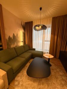 a living room with a green couch and a table at SkyHill Jahorina Gondola Poljice Newly Opened in Jahorina