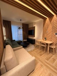 a living room with a couch and a table at SkyHill Jahorina Gondola Poljice Newly Opened in Jahorina +4 photos