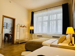 a bedroom with two beds and a large window at City Apartment 920 in Pardubice