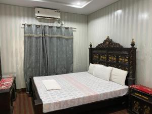 a bedroom with a large bed with a wooden frame at Getaway lodge Guesthouse in Islamabad +6 photos