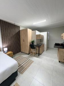 a bedroom with a bed and a desk and a kitchen at Green Haven Waitara in Tzaneen
