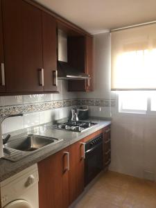 a kitchen with a sink and a stove top oven at Atelier de lujo lucena in Lucena