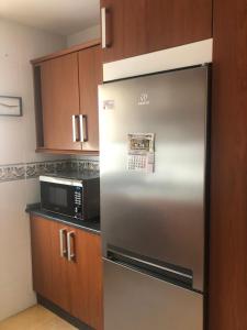 a stainless steel refrigerator in a kitchen with a microwave at Atelier de lujo lucena in Lucena