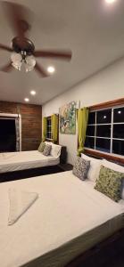 a bedroom with two beds and a ceiling fan at Finca El Monasterio in Rivas