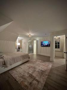 a bedroom with a bed and a flat screen tv at Blatchley Rooms by Yale in New Haven