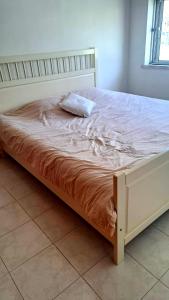 a bed with a pillow sitting on top of it at Cozy Room in Corroios Near Beach & Lisbon - Quarto Acolhedor em Corroios Perto da Praia e Lisboa in Corroios