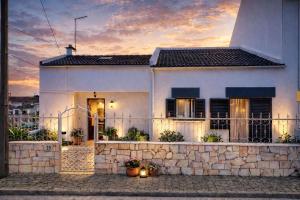 a white house with a stone wall at Cozy Room in Corroios Near Beach & Lisbon - Quarto Acolhedor em Corroios Perto da Praia e Lisboa in Corroios