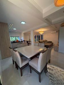 a living room with a white table and chairs at Casa da Palmeira com Piscina in Piratuba