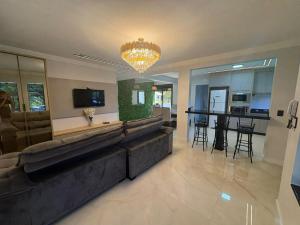 a living room with a large couch and a chandelier at Casa da Palmeira com Piscina in Piratuba