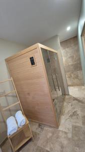 a large wooden bathroom with a shower and towels at Love room- Le Cocon Osé in Autun +17 photos