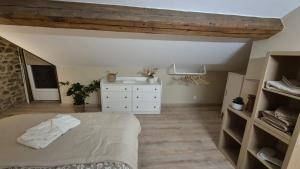 a bedroom with a bed and a white dresser at Love room- Le Cocon Osé in Autun