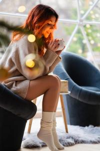 a woman sitting in a chair looking at her cell phone at Rum nore in Disah
