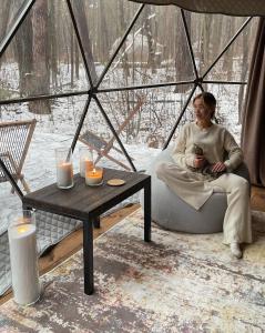 a woman sitting in a tent with a table and candles at Rum nore in Disah