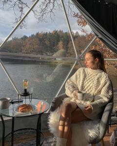 a woman sitting in a chair with a cup of coffee at Rum nore in Disah