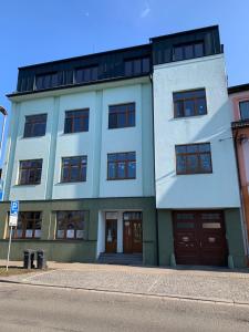 a white building with brown doors on a street at City Apartment 920 in Pardubice