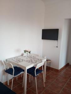 a white dining room table with chairs and a tv at Lucia Home in Moya