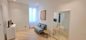 a living room with a blue chair and a television at Casa Mafalda in Torre Boldone