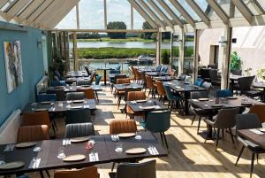 a restaurant with tables and chairs in a room at Hotel am Hafen Leverkusen in Leverkusen