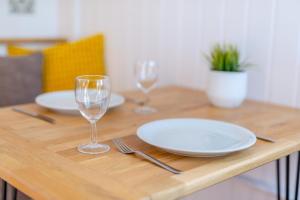 a wooden table with plates and wine glasses on it at 1 Bed in Saltfleetby oc-b30072 in Saltfleetby Saint Peter