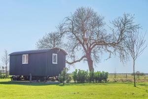a small black house in a field with a tree at 1 Bed in Saltfleetby oc-b30072 in Saltfleetby Saint Peter +12 photos