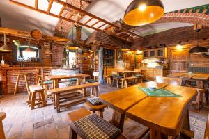 a restaurant with wooden tables and wooden chairs at Selská chalupa Anetka in Horšovský Týn