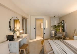 a bedroom with a large bed and a mirror at Nomāde Agora Suites - Lixouri Town Centre, Kefalonia - Private Balconies in Lixouri
