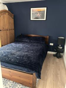 a bed in a bedroom with a blue wall at Swansea Waterfront in Swansea