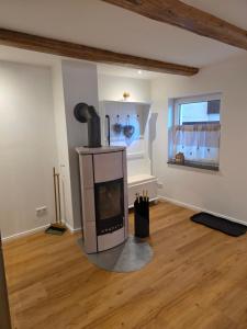 a living room with a fireplace in the middle at Unter den Balken - mit Ofen & Ruhe Keine Monteure! in Nörten-Hardenberg