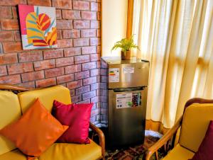 a small refrigerator in a living room with two chairs at Arica Surf & Beach House in Arica