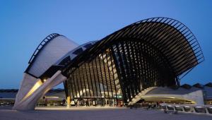 a large building with a curved roof at Ma maison fleurie proche AEROPORT LYON ST EXUPERY, LDLC ARENA, Groupama Stadium,Eurexpo in Janneyrias