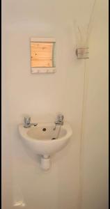 a white sink in a white bathroom with a window at An Gearasdan in Eoropie +17 photos