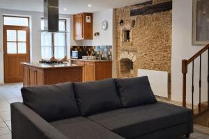 a living room with a couch and a kitchen at L'instant doré in Charnay