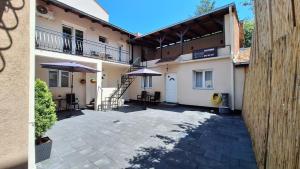 a building with a patio with tables and umbrellas at Apartments & Dream Rooms in Niš