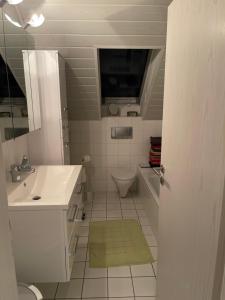 a white bathroom with a sink and a toilet at Altrhein Hideaway ruhige Ferienwohnung nahe Frankfurt ideal für Natur & Radfahrer in Riedstadt +12 photos