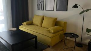 a living room with a yellow couch and a table at Apartmán Jungmannka in Bruntál