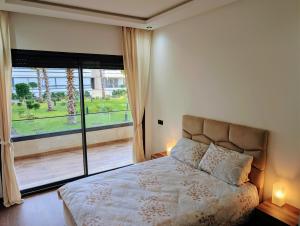 a bedroom with a bed and a large window at Pool view apartment, beach access, nature & quiet in Mansouria +12 photos