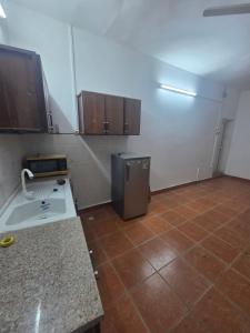 a kitchen with a refrigerator and a tile floor at Studio Cite Progres in Djibouti