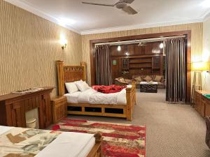 a bedroom with a bed and a living room at Alaf Laila Guest House in Abbottabad