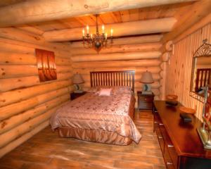 a bedroom with a bed in a log cabin at Le Chalet Bois Rond Relax in Saint-Tite-des-Caps